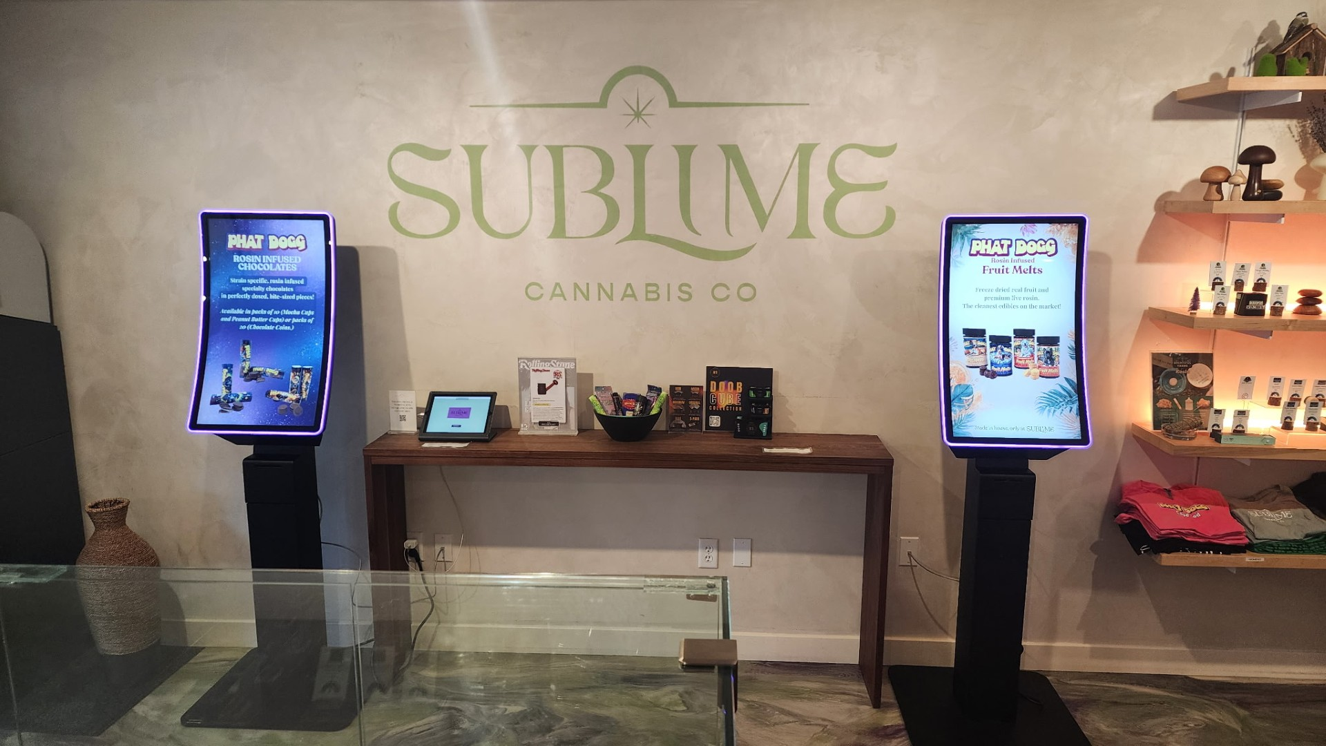 Two Dispensify self-service kiosks installed beneath the Sublime Cannabis Co. wall logo in the Mashpee, Massachusetts dispensary.