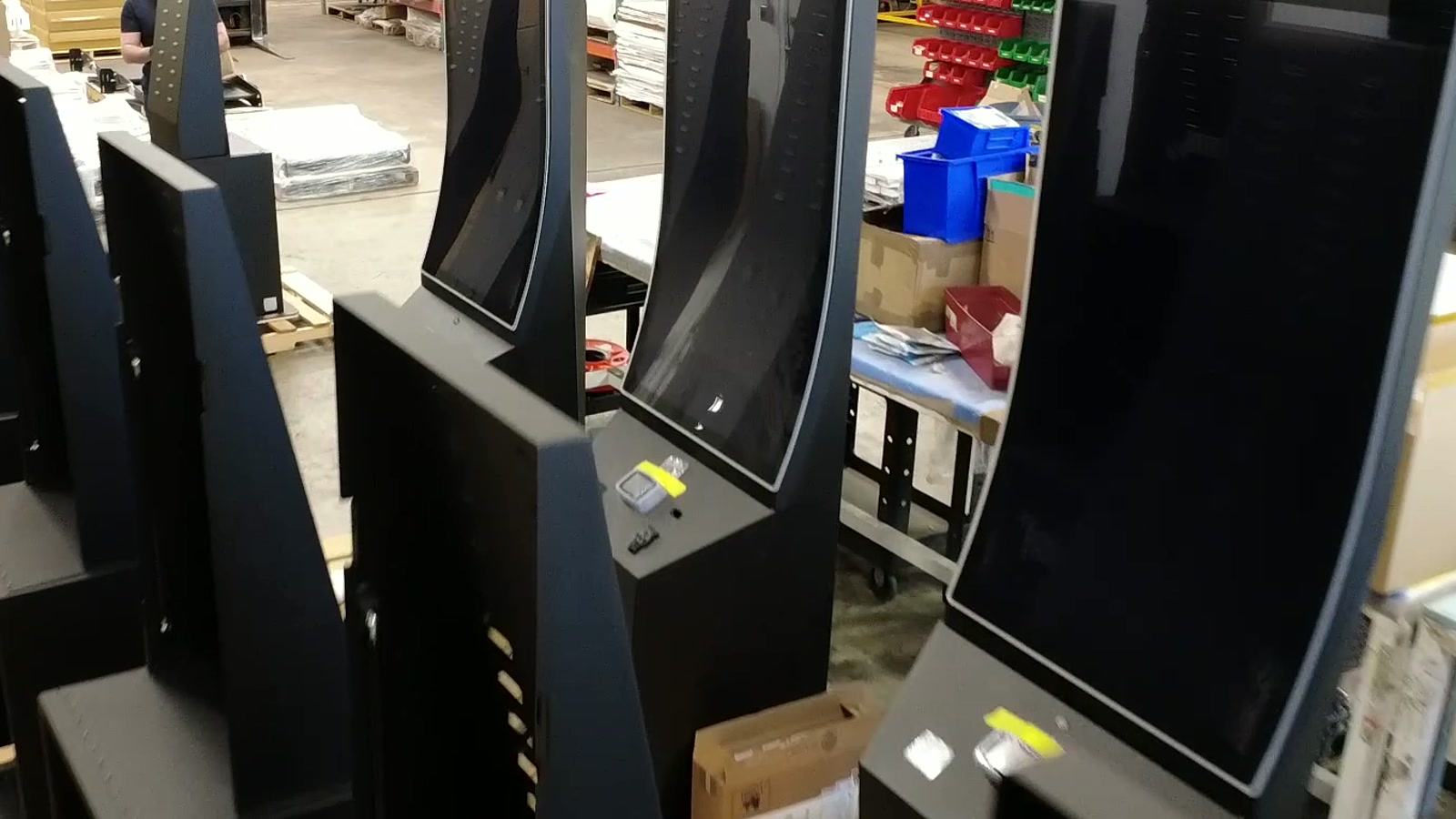 Rows of Giosk 32 Cash kiosks staged during hardware preparation for dispensary cash checkout lanes